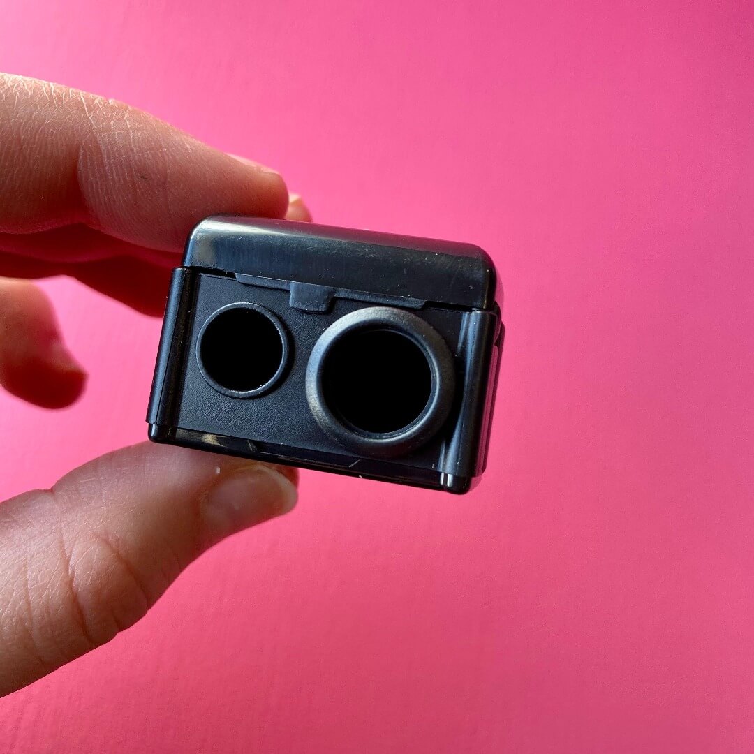 Image de l'aiguisoir à crayons cosmétiques ARTIST. À gauche se trouve le petit trou pour les crayons de taille normal. Le trou de droite est plus large pour les crayons jumbos. 